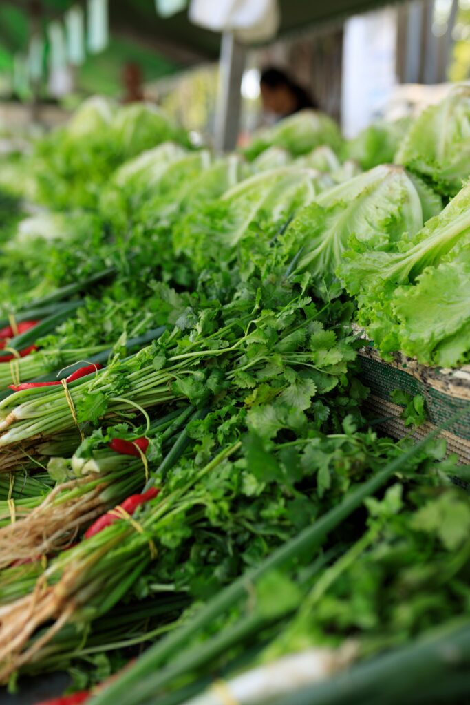 Fresh greens and vegetables stacked at a Korean traditional market