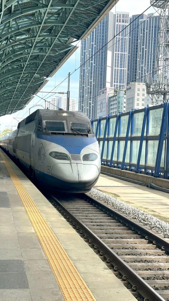 A KTX high-speed train waiting at a station platform in Korea