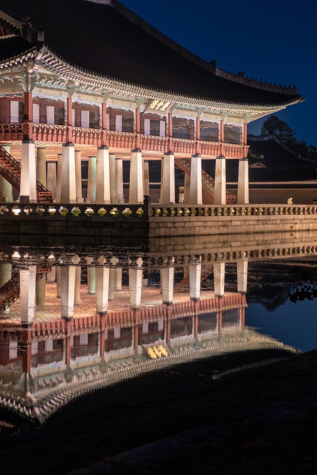 Gyeonghoeru pavilion and its full reflection in the pond at blue hour