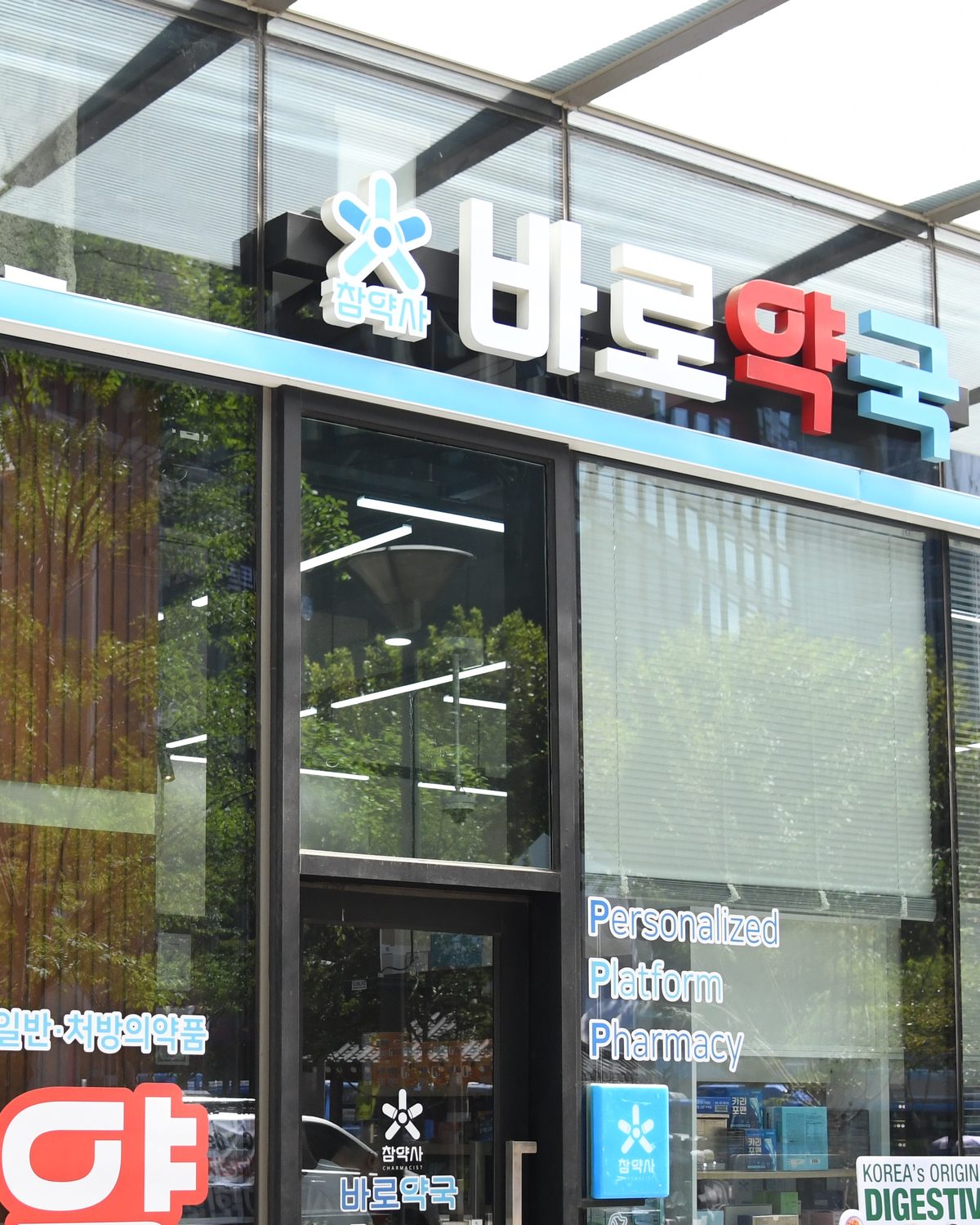 A Korean pharmacy storefront with the 약국 sign above the door and a large red 약 in the window
