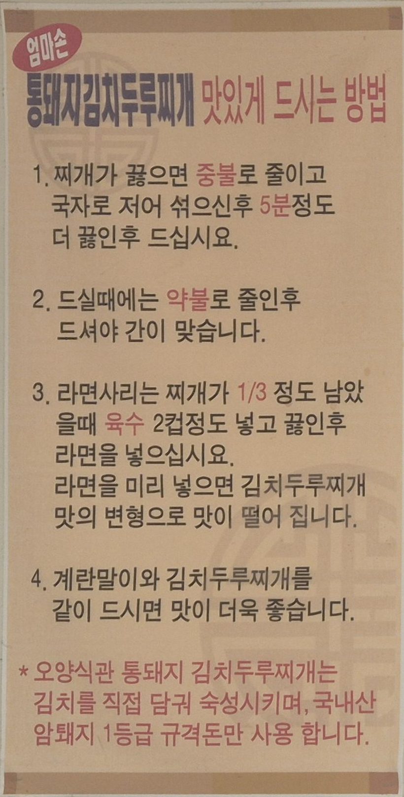 The cream-coloured sign on the wall, 'How to enjoy our whole-pork kimchi stew': four numbered steps in Korean, with a promise about the kimchi and the pork in red at the bottom.