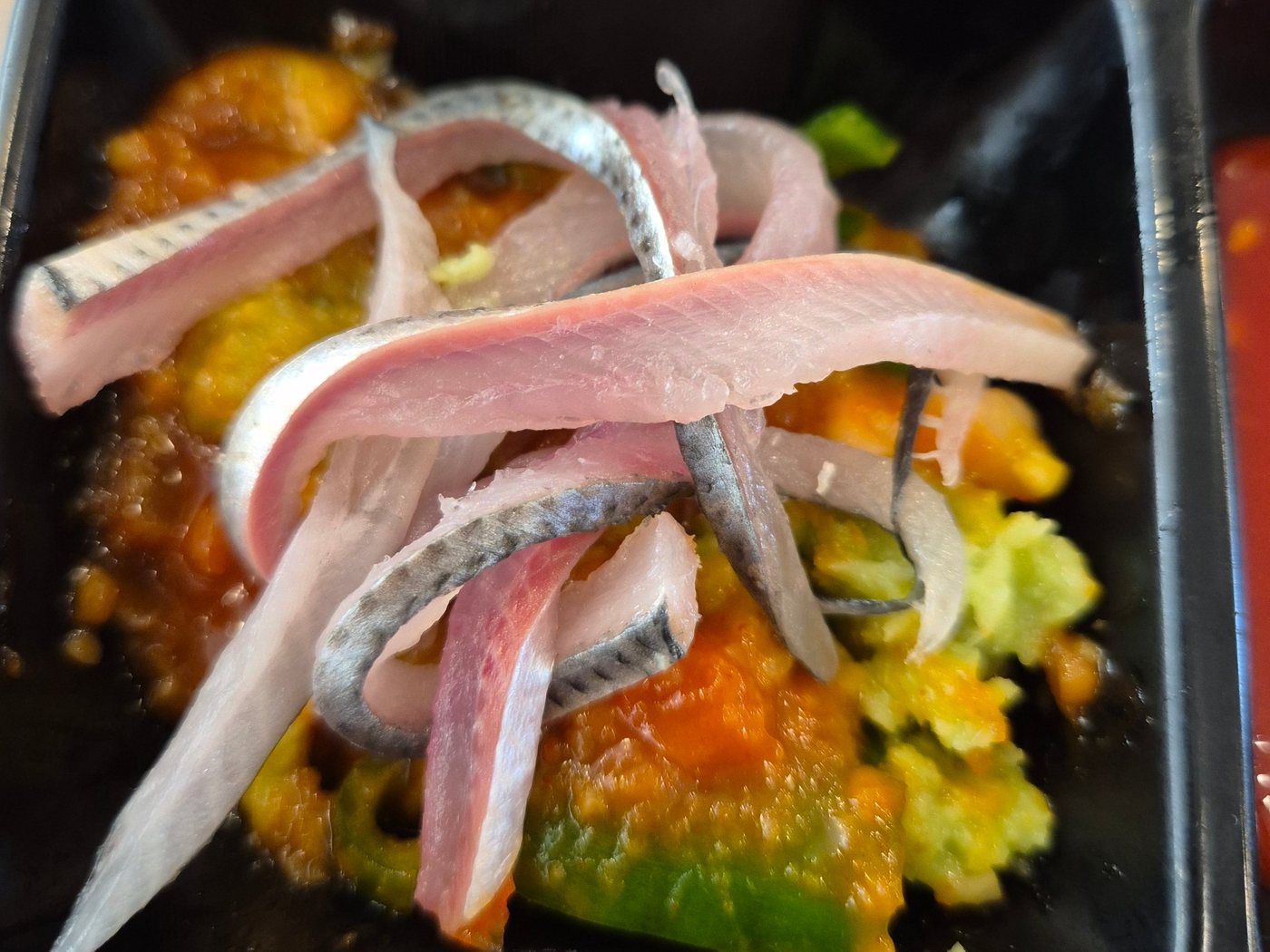 A few slices of shad sashimi resting on top of the magic sauce.